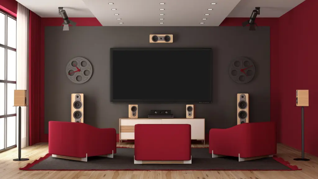 Un lujoso home theater contemporáneo con una pared central de acento gris, equipada con un gran televisor.