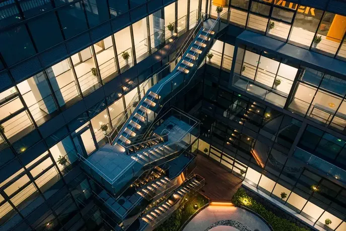 Estructura nocturna de edificios inteligentes destacando sus escaleras y luces de diseño