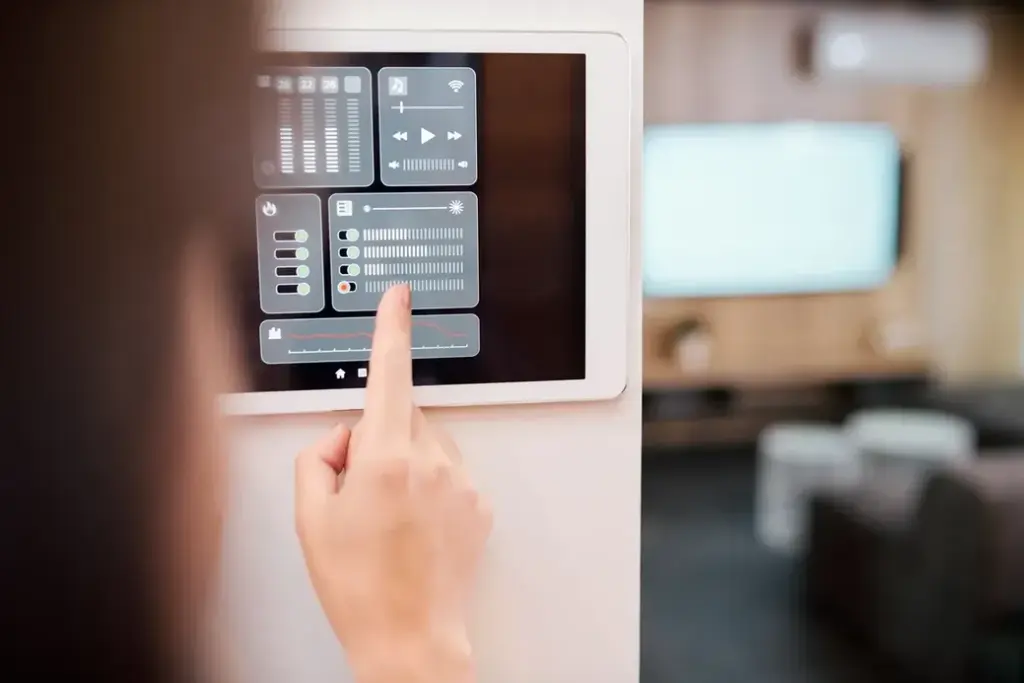 Panel de control para la integración de sistemas del hogar Persona interactuando con una tablet en la pared para la integración de sistemas domóticos